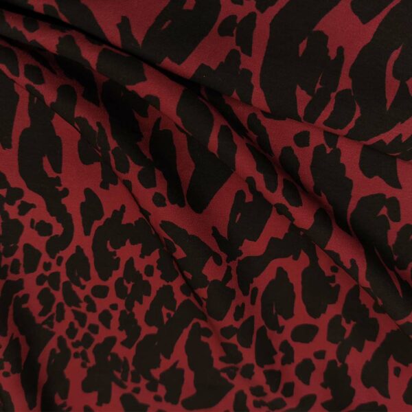 Tessuto Crepe a fantasia motivo animalier bordeaux - nero