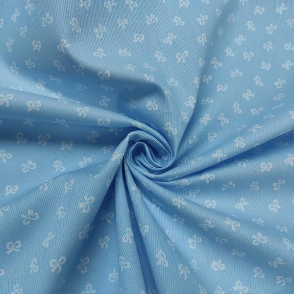 Tessuto Millerighe di Cotone a fantasia motivo fiocchi celeste - bianco